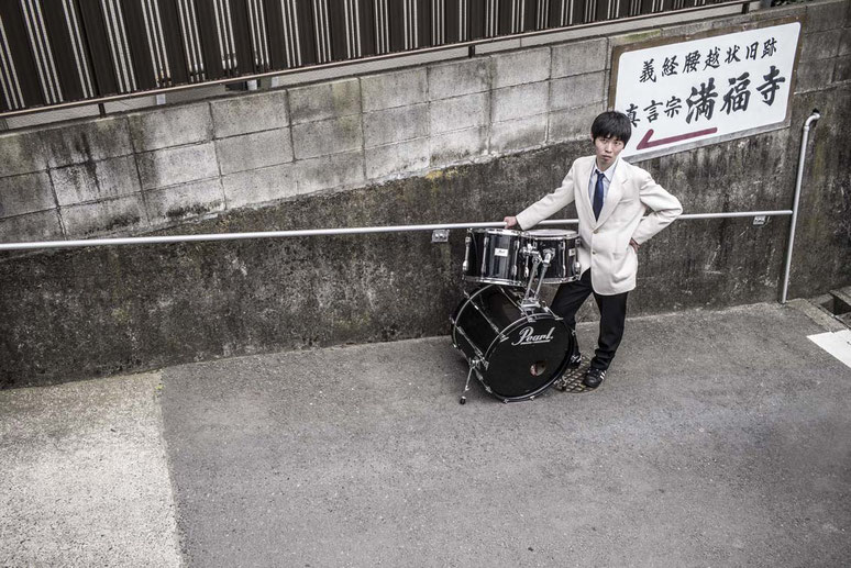 Schlagzeugspieler mit Schlagzeug auf einer Straße in Enoshima, Japan als Farbphoto