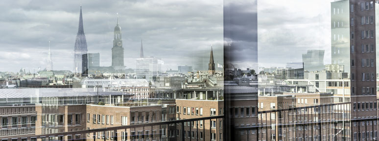 Spiegelung der Stadtübersicht auf der Aussichtsterasse der Elbphilharmonie in Hamburg als Farbphoto im Panorama-Format. 