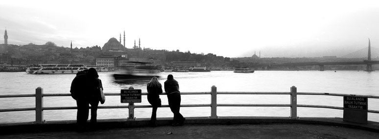 Abendstimmung an der Galata Brücke in Istanbul, Türkei als Schwarzweißphoto im Panorama-Format