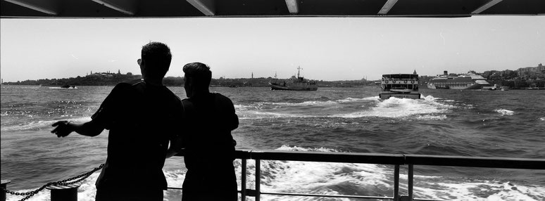 Auf der Fähre mit Blick über den Bosporus in Istanbul, Türkei als Schwarzweißphoto im Panorama-Format