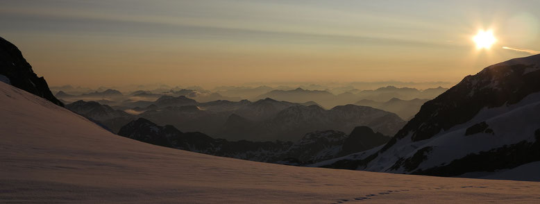 Morgenstimmung vor der Marco e Rosa Hütte. Unter der Sonne die Fortezzafelsen des Palü. Unmittelbar links davon die Gipfel des Val da Camp