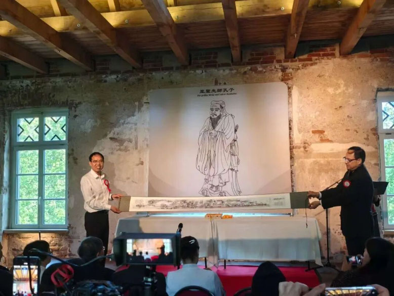 南孔75代世孙孔火明参加德国祭孔活动体会-2025年德国纪念孔子诞辰活动现场，王莉院长把《孔氏南宗家庙赋》卷轴赠送环节特别安排在典礼流程之前，给整个祭孔活动增加了浓厚的氛围，