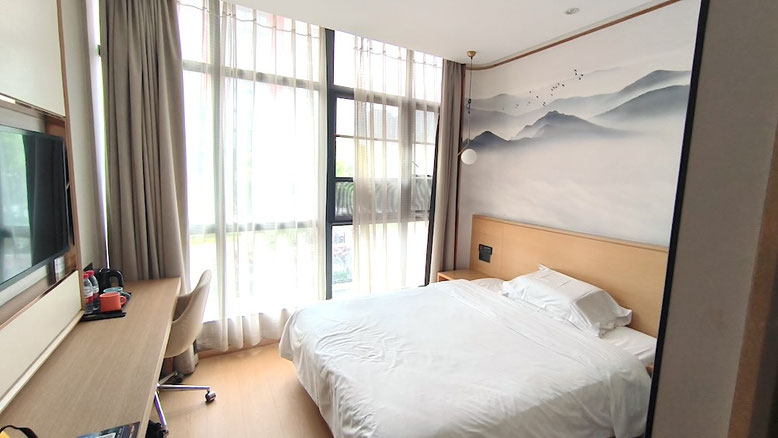 Camera d'hotel moderna in Cina con letto matrimoniale, scrivania e ampia finestra