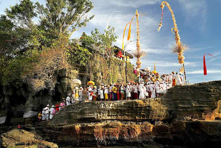 tempio a Bali con cerimonia tradizionale e fedeli in abiti bianchi durante un rituale religioso in Indonesia