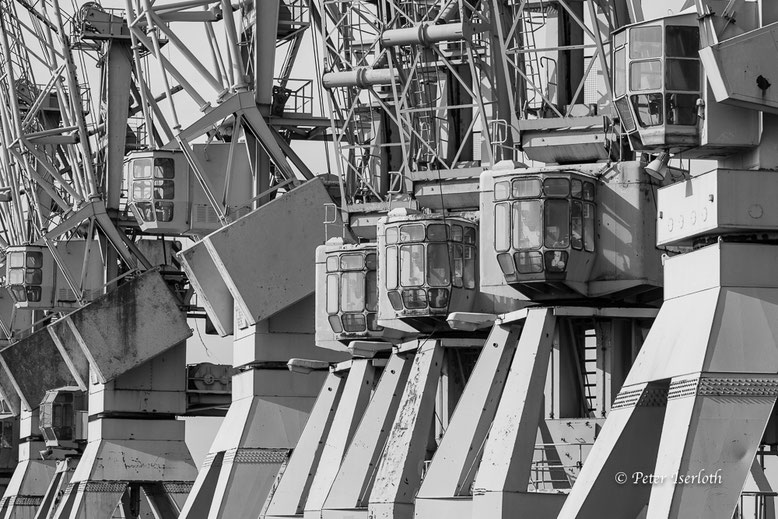 Krankanzeln im Museumshafen Hamburg, durch ein Teleobjektiv ist die Perspektive verdichtet. Das Bild zeigt sechs Kanzeln in einer Reihe.
