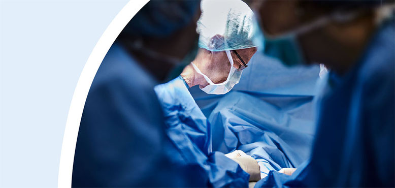 Chirurgen in OP-Kleidung und Mundschutz während einer Operation im Operationssaal.