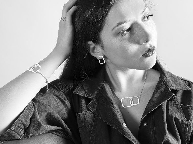 jeune femme accoudée qui porte un collier, un bracelet et des boucles d'oreilles en argent recyclé de la collection Quadra