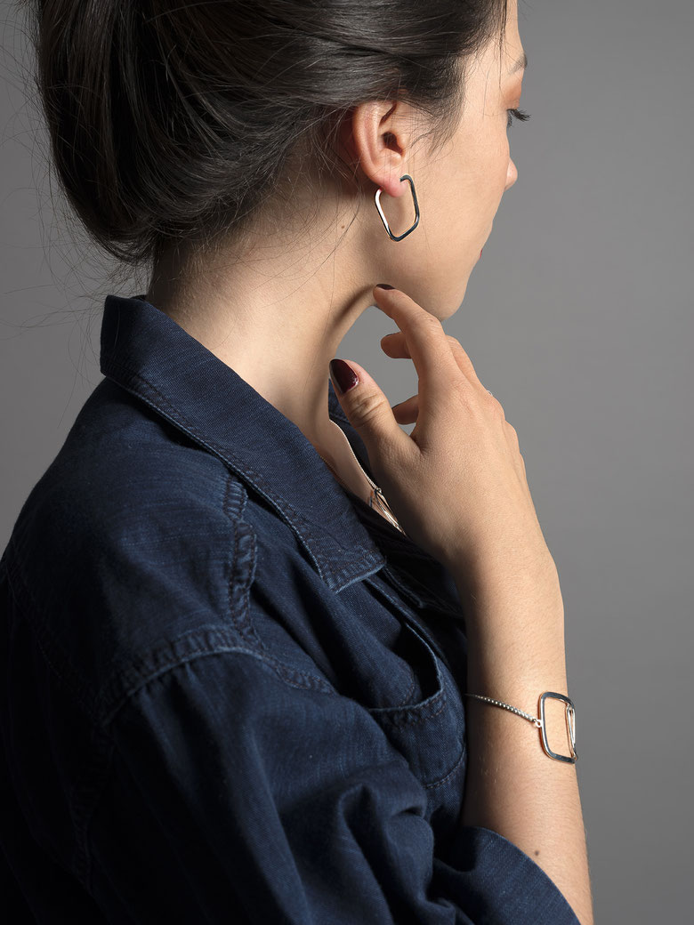 jeune femme de profil portant des boucles d'oreilles Q09 et un bracelet Q06 en argent recyclé de la collection Quadra