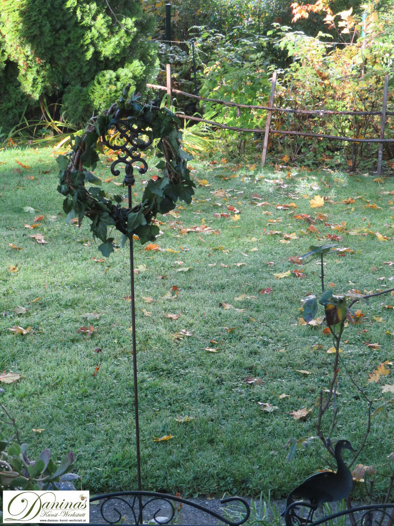 Herbstkranz aus Weinreben mit Efeu am frostigen Morgen im Garten