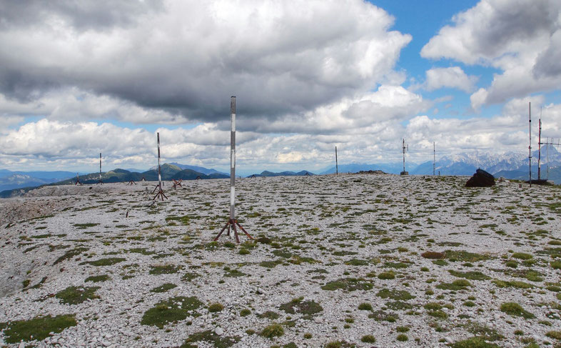Blick nach Osten, über das maschinell eingeebnete Gipfelplateau des Monte Scinauz. Teile der ehemaligen Empfangseinrichtungen, sowie aktive Mobilfunk und Radioantennen finden sich überall verstreut.