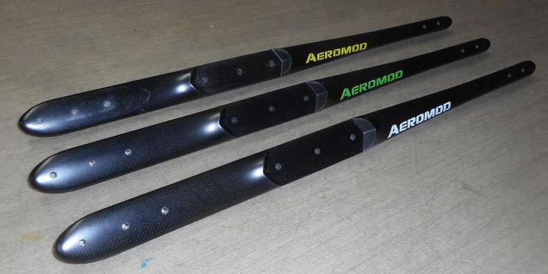 3 fuselages de wingfoil aeromod, de couleur noir carbone apparent, et couleur secondaire : un blanc, un vert pomme, un jaune