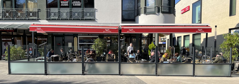 Die Kombination aus Glas und Sichtschutz-Elementen bietet an dem Eiscafé einen eleganten und windgeschützten Außenbereich für die Gäste