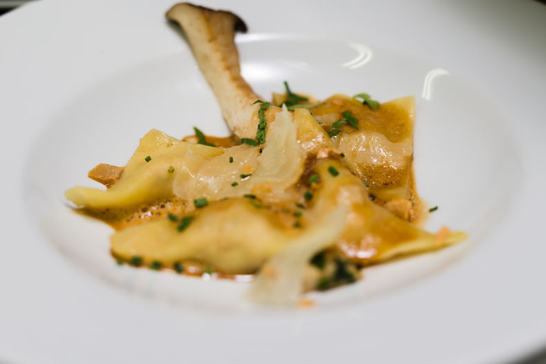 Hausgemachte Kaninchen-Ravioli mit gebratenen Kräuterseitlingen, geröstetem Knoblauch und Manchego