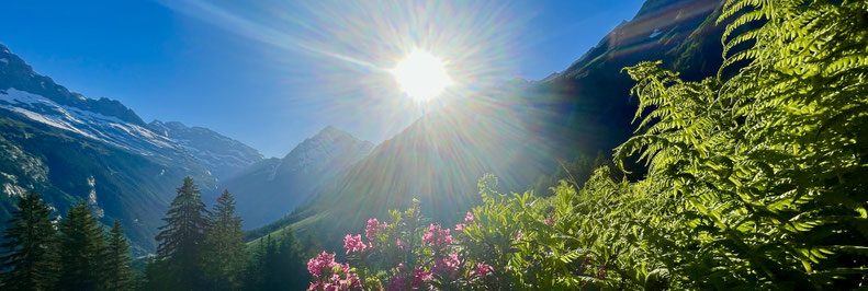 eine malerische Berglandschaft, mit Sonnenstrahlen, die durch die Wolken brechen und einen klaren Blick auf den Horizont freigeben.