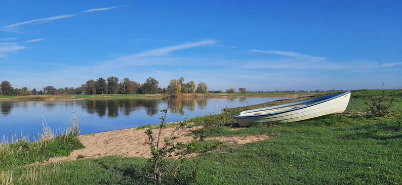 Ein kleines Boot liegt am Ufer eines Flusses