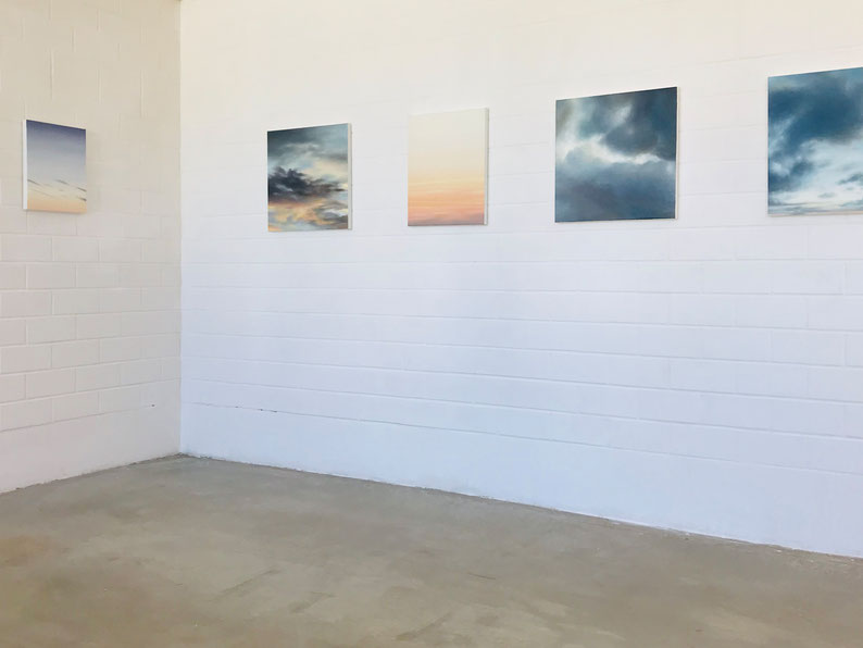 Ansicht von mehreren gemalten Wolkenbildern in einem Ausstellungsraum