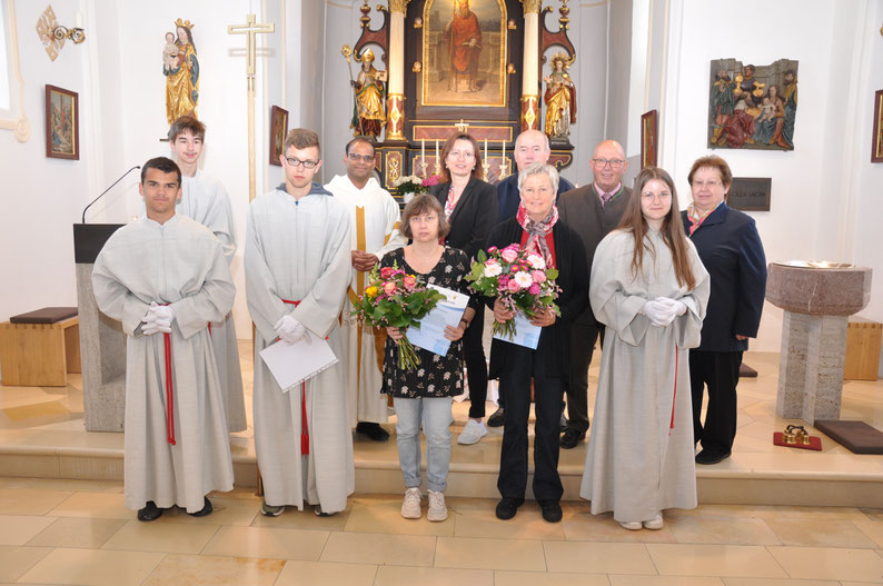 Foto: Die verabschiedete Ministrant Martin Hacker (in der Mitte mit Urkunde), daneben Ilona Fruhmann und Maria Berg mit Pfarrvikar Cleetus Unnikunnel, der Pfarrgemeinderatsvorsitzen, den Mesnern, dem Kirchenpfleger und den Vilslerner Ministranten