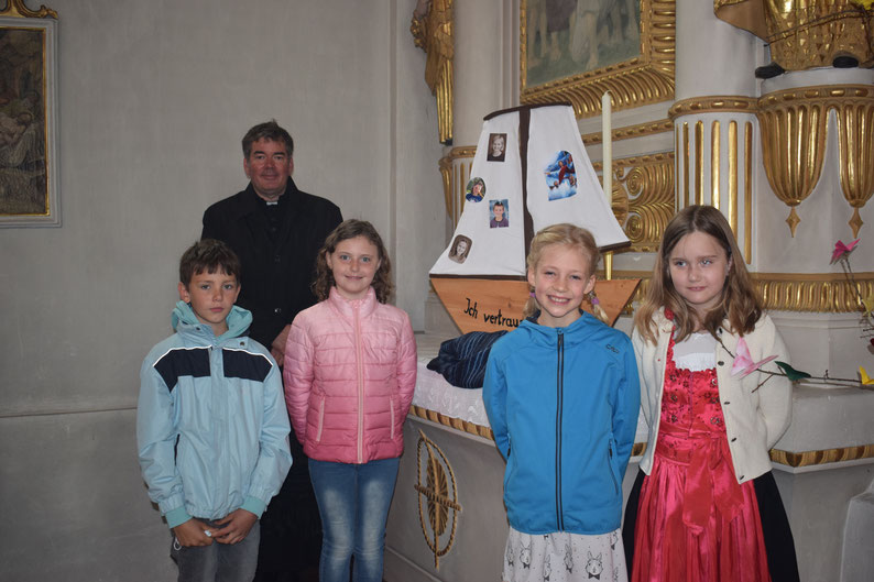 Abbildung: Dekan Tobias Rother mit den Erstkommunionkindern, Vitus Berndl, Magdalena Eglhuber, Theresa Unterreithmeier und Emma Ippenberger.