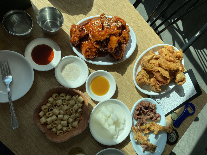 il pollo fritto di Suwon, nella versione al miele e agrodolce, servito con zampe di gallina fritte, chips e salsine varie