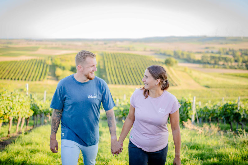 Paar geht Hand in Hand durch den Weinberg in Rheinhessen, nachhaltige Mode von Rhoihesse on Tour