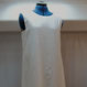 Sur l'image, une robe sans manches en lin blanc et avec une bande large en bas en lin café. Réalisation sur commande par la maison de couture Fil et Paillettes. 