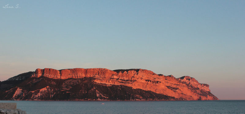 La roche rouge du Cap Canaille (ici intensifiée par la lumière du coucher du Soleil) est composée de calcaires détritiques (roches sédimentaires constituée de débris).