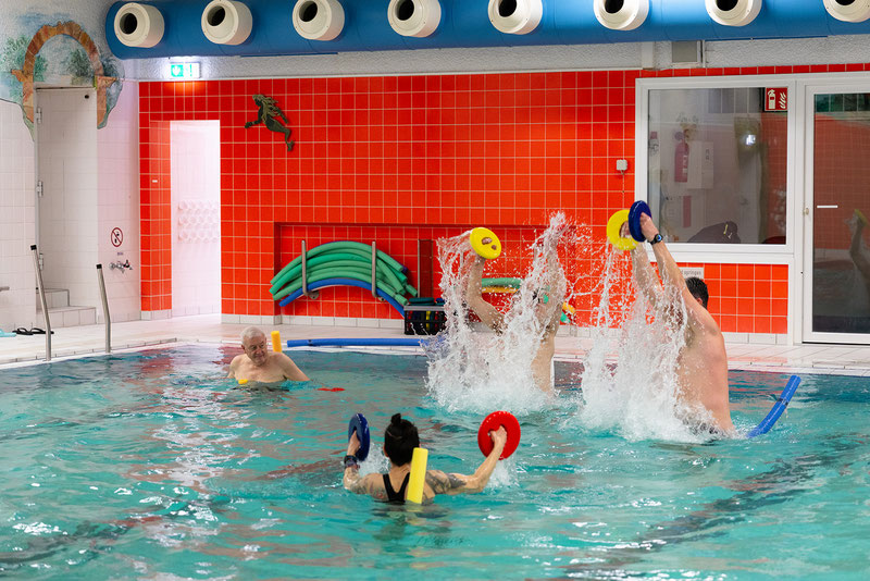 Wassergymnastik-Reha-Sport-Gruppe des BSV Achim trainiert im Schwimmbecken mit Auftriebsscheiben und dynamischen Übungen für Kraft und Koordination.