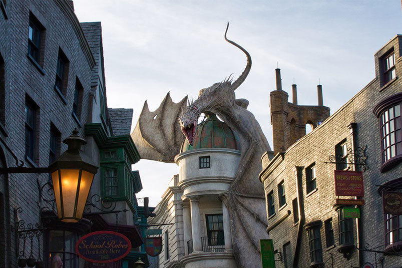 巨大なドラゴンの像が建物の屋上に乗りかかる、ユニバーサル・オーランド・リゾートのハリー・ポッターエリア「ダイアゴン横丁」。映画の世界を忠実に再現した街並みが広がり、テーマパークのほかホテルやショッピング、レストランも併設された複合型リゾート。家族旅行はもちろん、大人のナイトライフやグルメも楽しめる人気観光スポット。