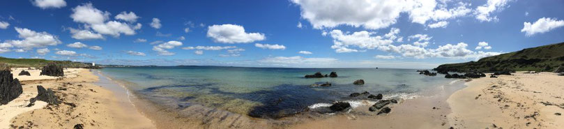 A panoramic photo of Singing Sands Beach and Carraig Fhada Lighthouse