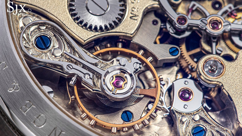 Detailreiche Makroaufnahme eines komplexen mechanischen Uhrwerks mit goldenen Zahnrädern, blauen Schrauben und präzise gefertigten Metallkomponenten