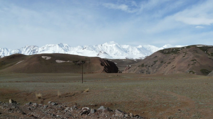 Les collines kirghizes devant la chaine des Pamirs