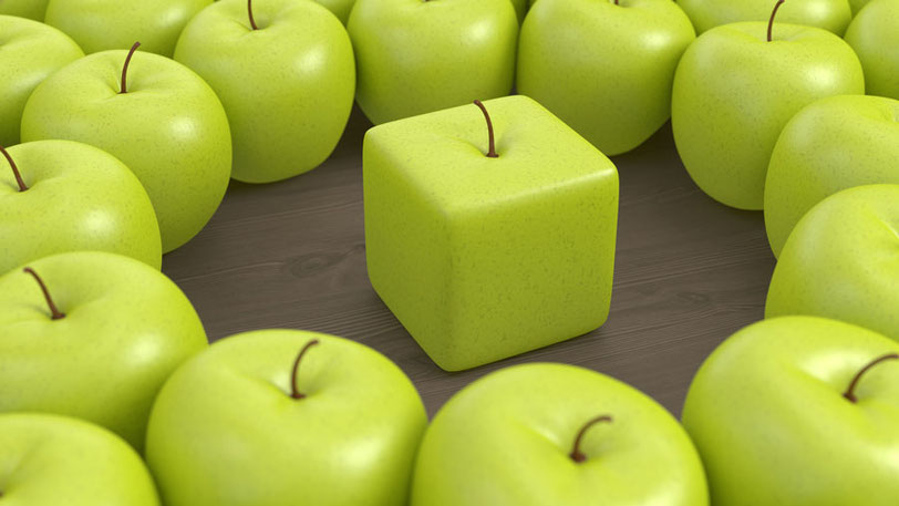 Ein quadratischer, grüner Apfel inmitten runder Äpfel derselben Sorte – symbolisiert Andersdenken, Individualität und kreative Lösungen bei juliaandfriends.de.