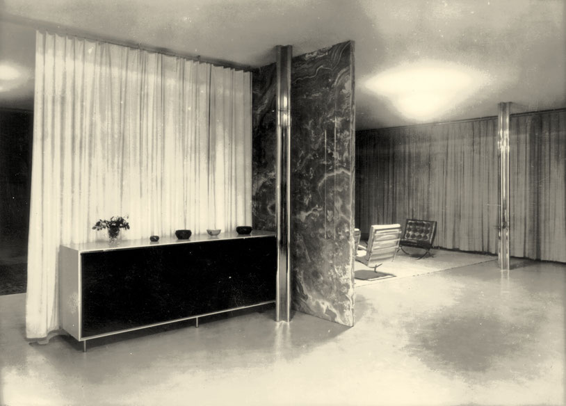 Cremeweißer LINOLEUM Boden und Samtvorhang, verchromte und hochpolierte Pfeiler, Wand: Onyx-Marmor, Sitzgruppe, Vorhänge:silbergraue SHANTUNG Seide, Stucco Lustro