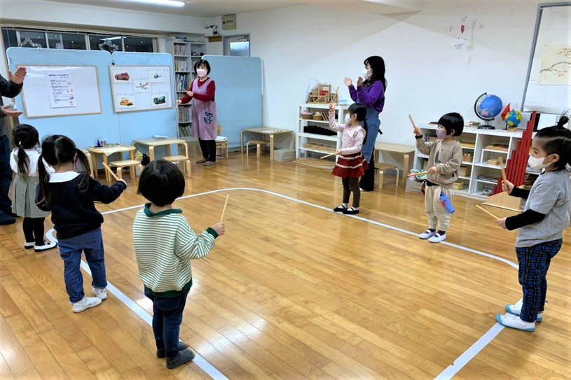 京都市の幼児教室幼稚園児クラスのリトミック。スティックで言葉のリズムを刻んでいます。