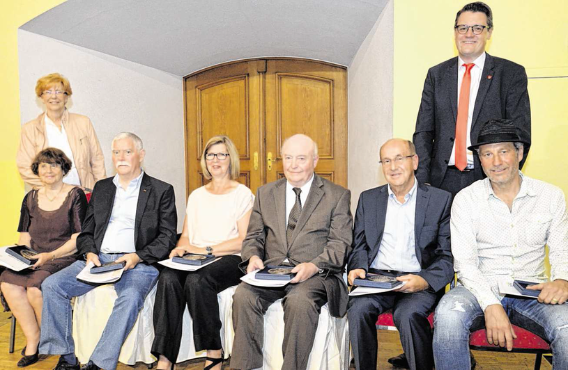 Marita von der Weiden (sitzend v. l.), Dieter Call, Christa und Karl-Heinz (nicht im Bild) Oedekoven, Hans Charles, Hartmut Kleis und André Hennecken sind von Bürgermeister Tim Grüttemeier und der Ehrenamtsbeauftragten Hildegard Nießen mit dem Ehrenamtspr