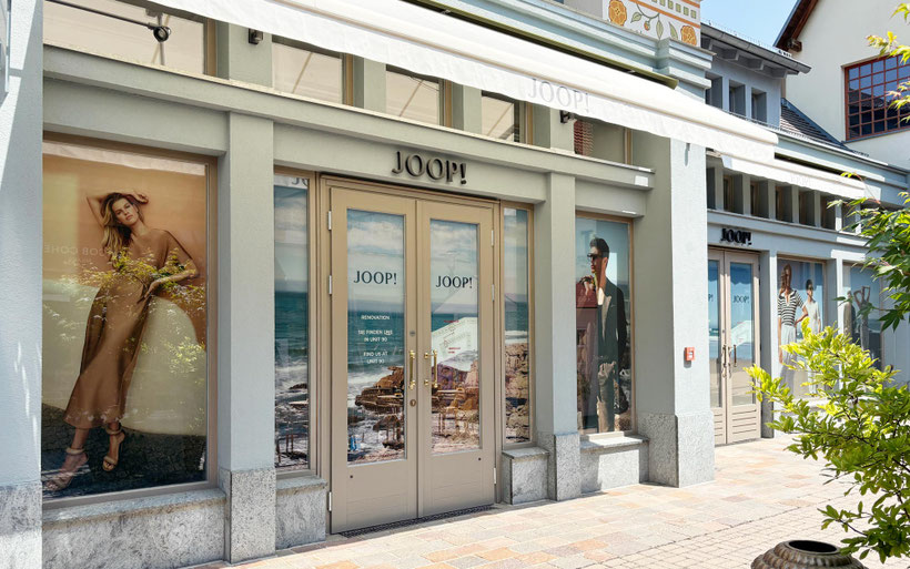 Komplett folierte Schaufensterfassade des JOOP! Stores im Wertheim Village mit bedruckter Fensterfolie als Sichtschutz für Umbauarbeiten