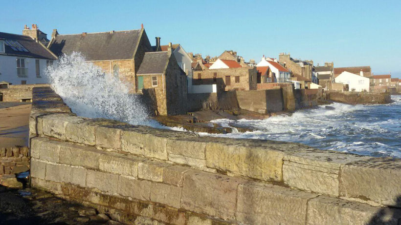 Waves splashing over the wall at Anstruther harbour