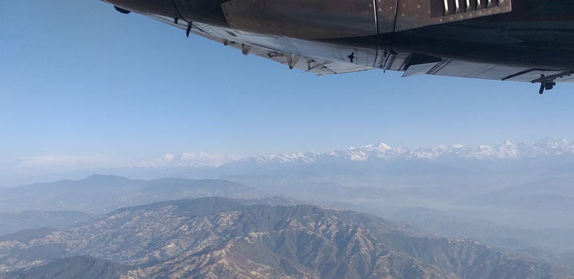 Ausblick aus dem Fenster auf Berge im Landeanflug Flughafen Katmandu 