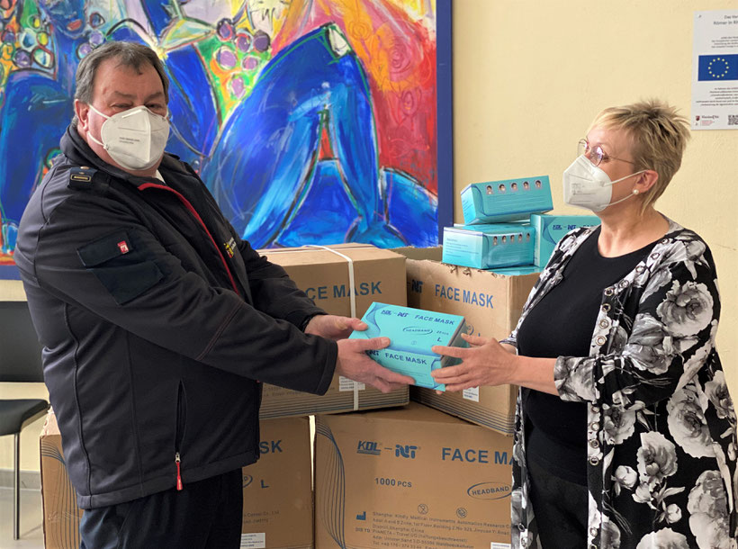 Landrätin Dorothea Schäfer übergibt Kreisfeuerwehrinspekteur Rainer Jacobus die Masken für den Katastrophenschutz. Foto: Kreisverwaltung Mainz-Bingen/Lara Dreesbach.