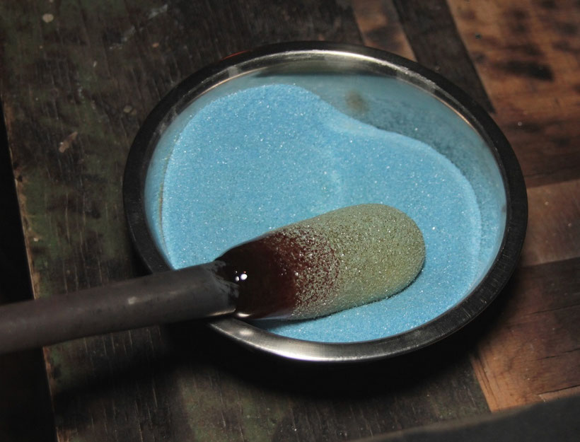 Ein Glasposten wird mit blauem Glasmehl eingefärbt