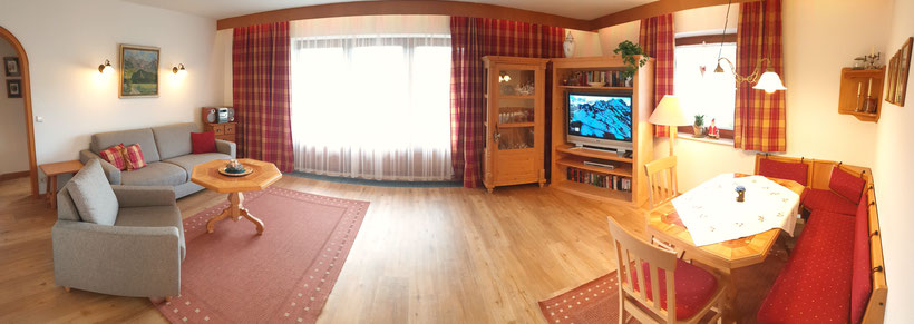 Ein gemütliches Wohnzimmer im Allgäuer Stil mit einer hellen Fensterfront