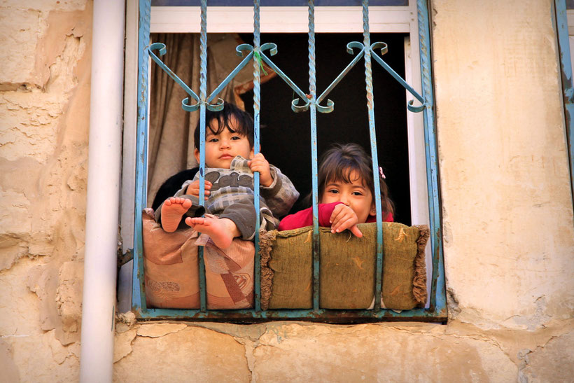 Kids sitting behind the window in the Old city of Nablus... © Sabrina Iovino | JustOneWayTicket.com