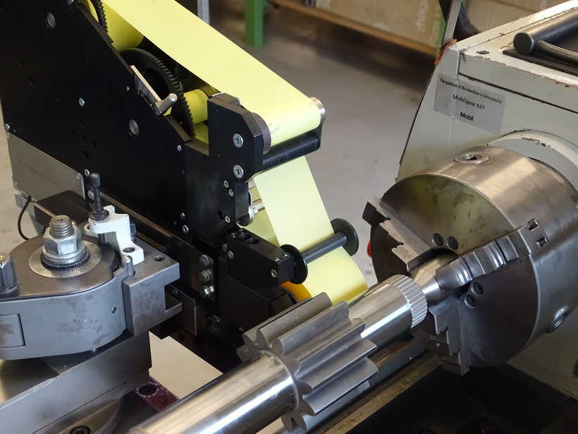 The picture shows a Microfinish attachment device mounted on a lathe