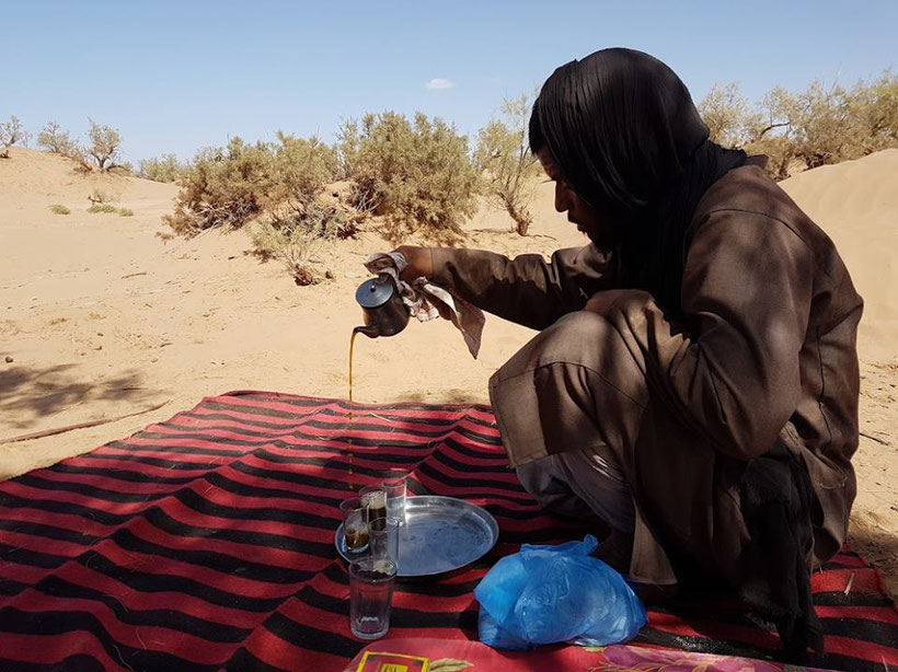 Nomade qui prépare le thé dans le désert