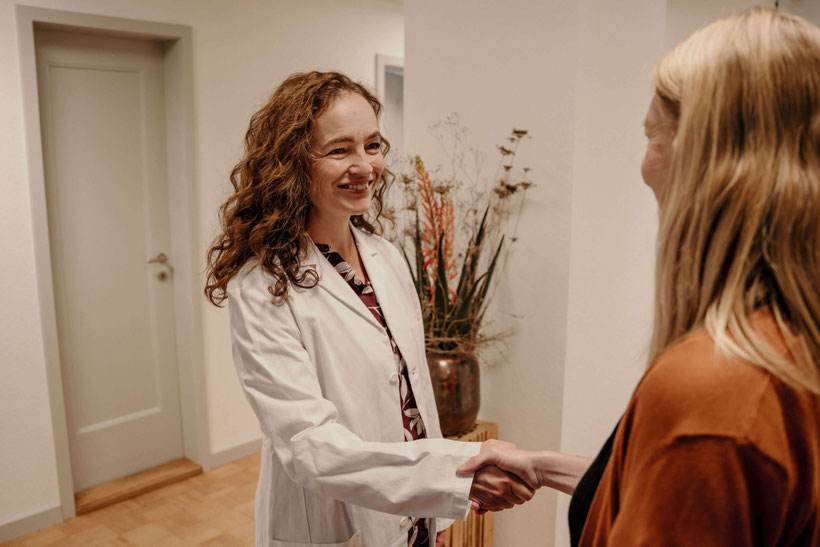 Dr. med. Susanne Constantinescu schüttelt lächelnd die Hand einer Patientin