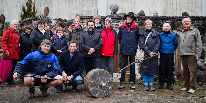 Gruppenfoto der Wanderer, die den Stoning Roll nach Wipperfürth bewegt haben, am Etappenziel bei Mirza Atug vor seinem Mahnmal aus Lavasteinen. Es soll an den Völkermord an den Aramäern erinnern.