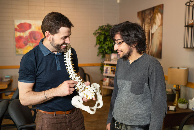 chiropractor showing spine model to patient