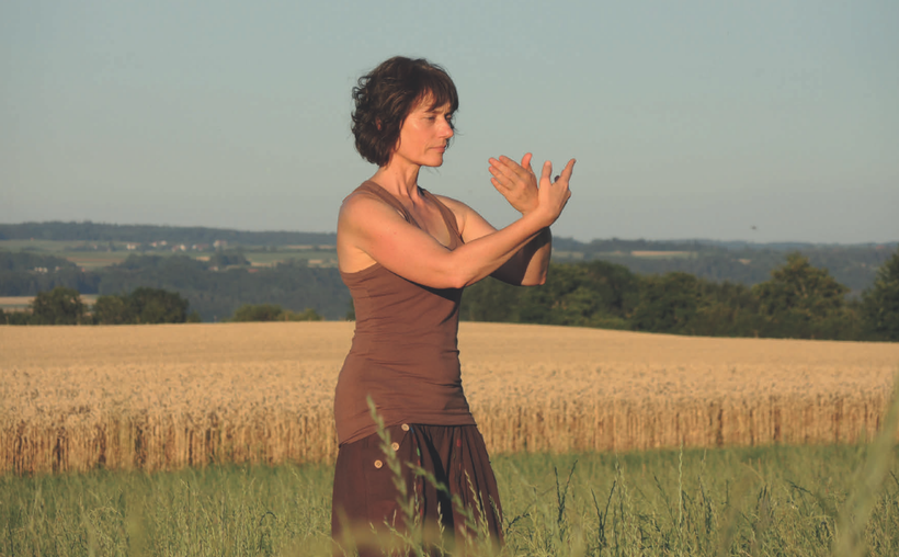 Karina Berg steht im ruhigen Tai Chi und Qi Gong Stand in der Natur