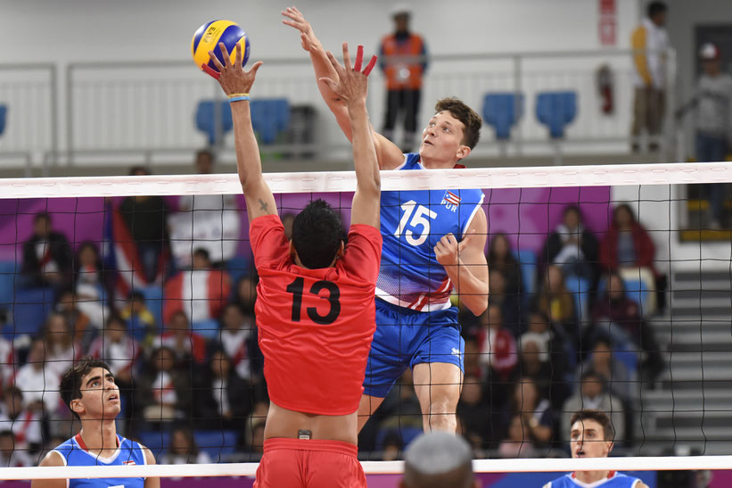 Jonathan Rodriguez (15) de Puerto Rico ataca por encima del bloqueo de los peruanos / foto por Norceca