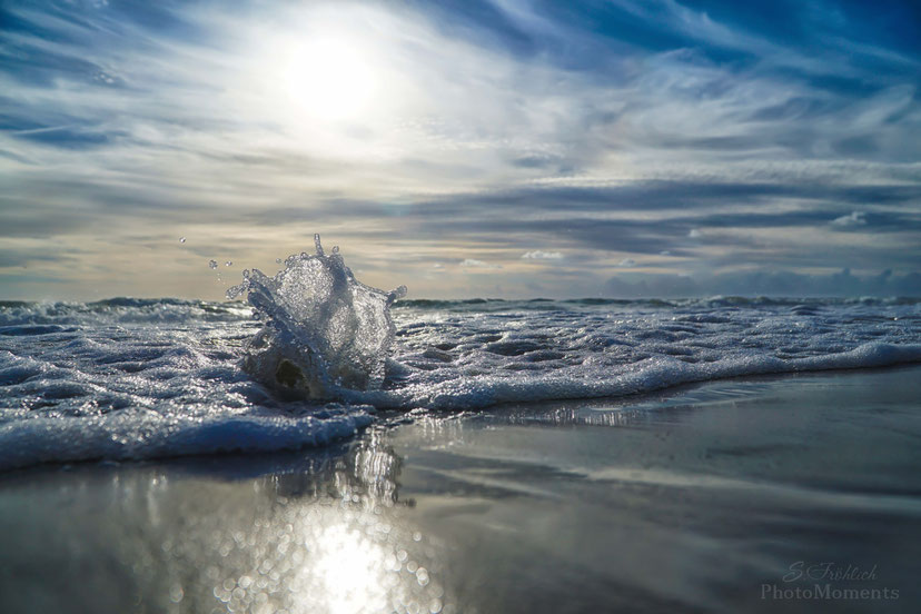 Glaskugel umspült von den Wellen des Meeres 